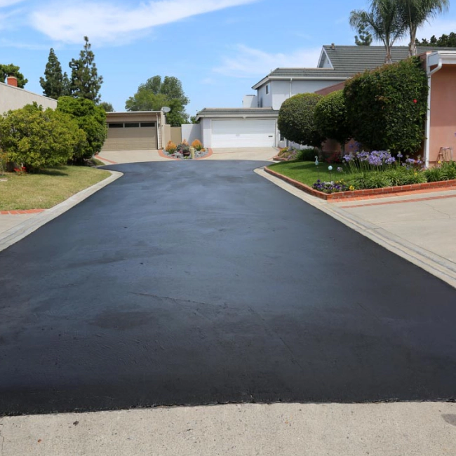 street driveway of a neighborhood with a asphalt sealcoating on