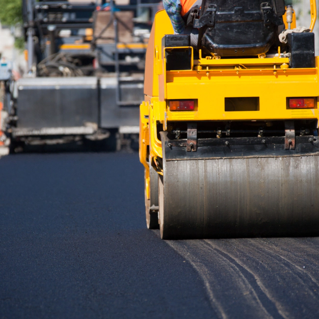 yellow construction machine paving a street